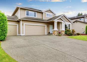 Neat beige home with two garage spaces and large concrete driveway. Northwest, USA